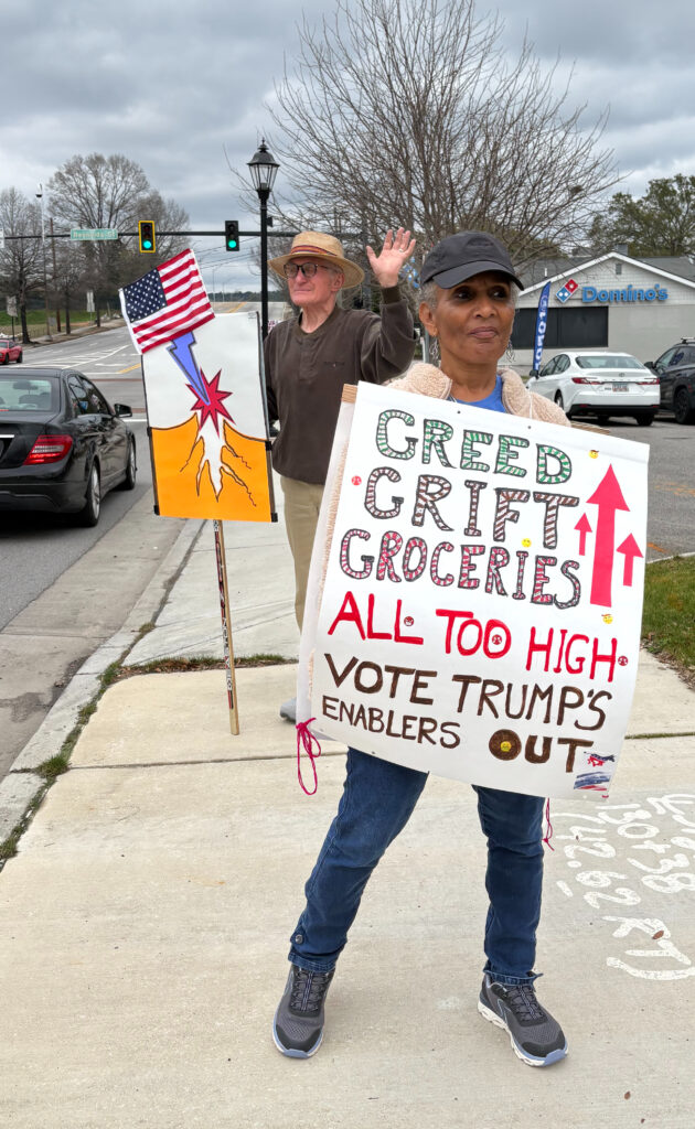 Protestors holding signs protesing Trump